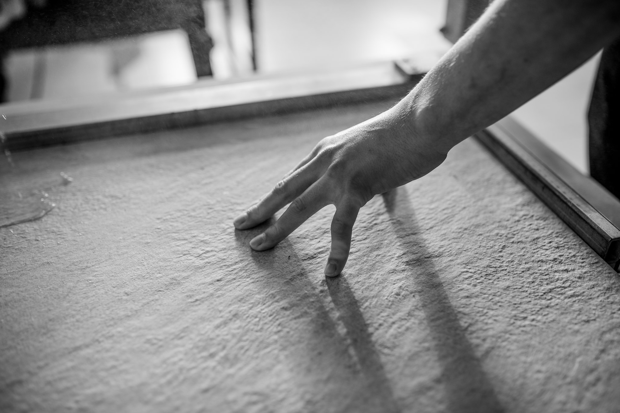 Fliesenleger prüft mit der Hand die Oberfläche einer Fliese