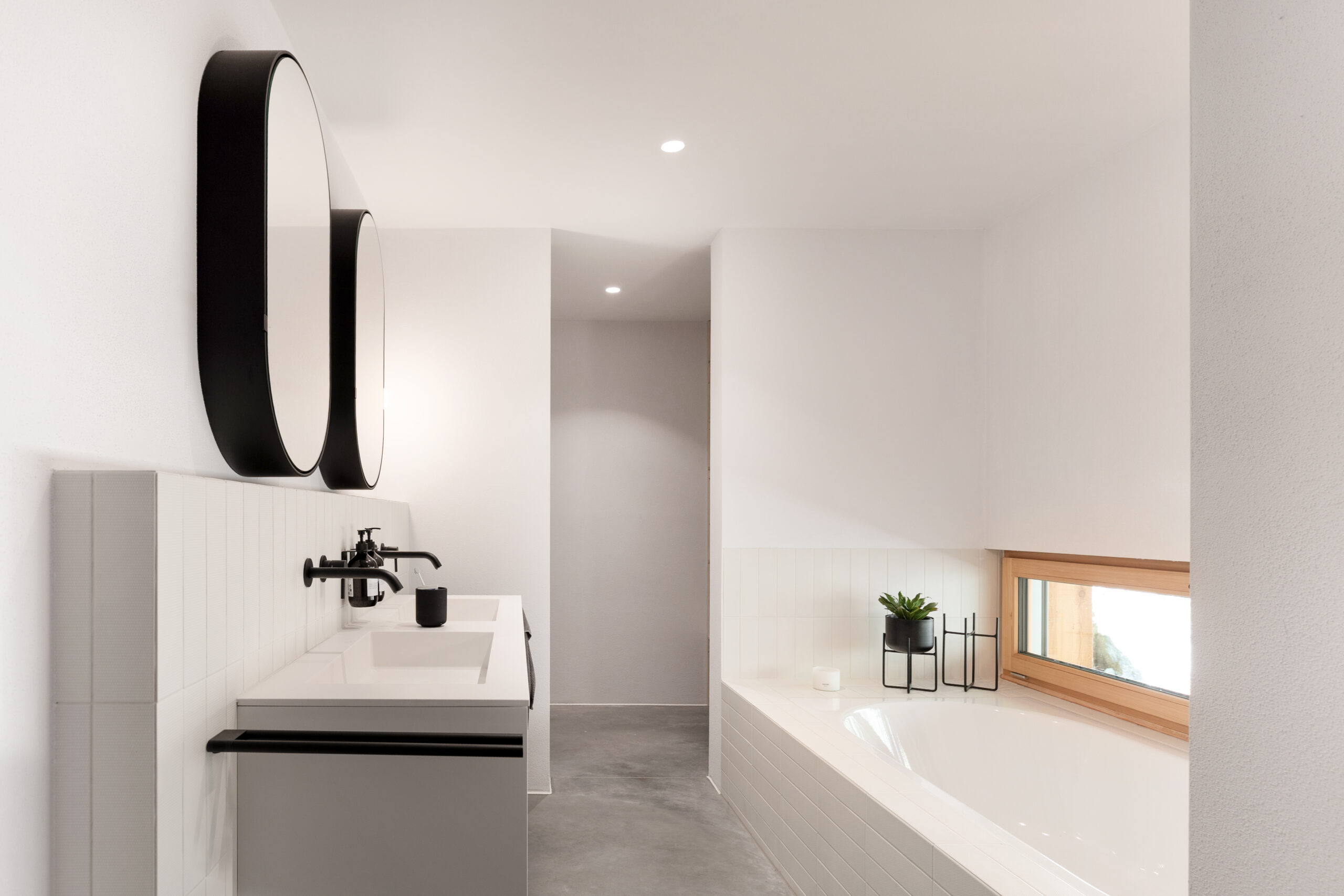 Modernes Badezimmer mit Waschtisch, schwarzer Armatur und Badewanne