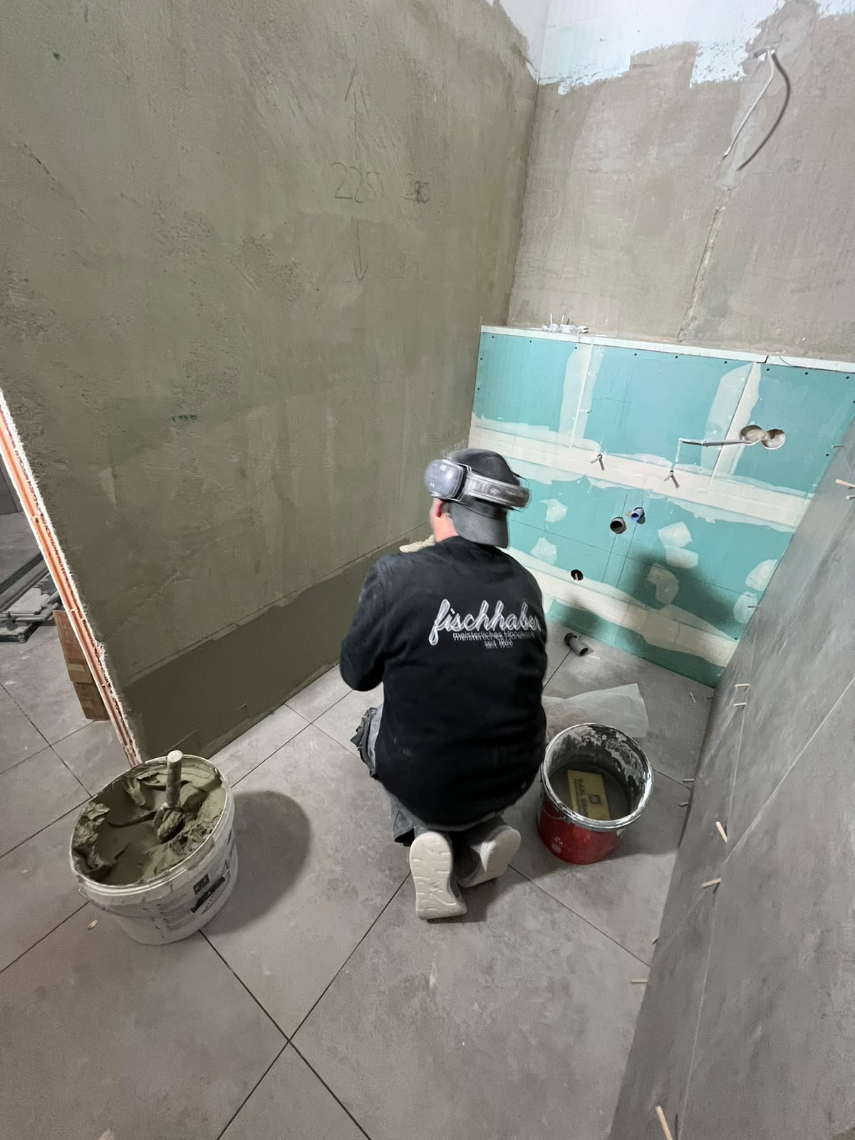 Handwerker beim Verputzen einer Wand während der Badsanierung