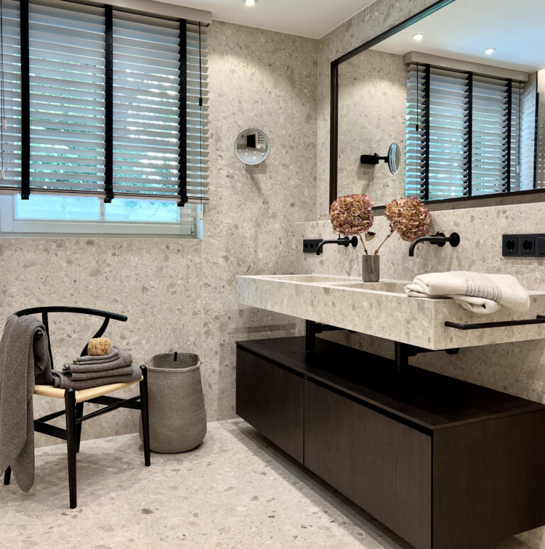 Badezimmer mit dunklem Waschtischunterschrank, Aufsatzwaschbecken und Wandarmatur