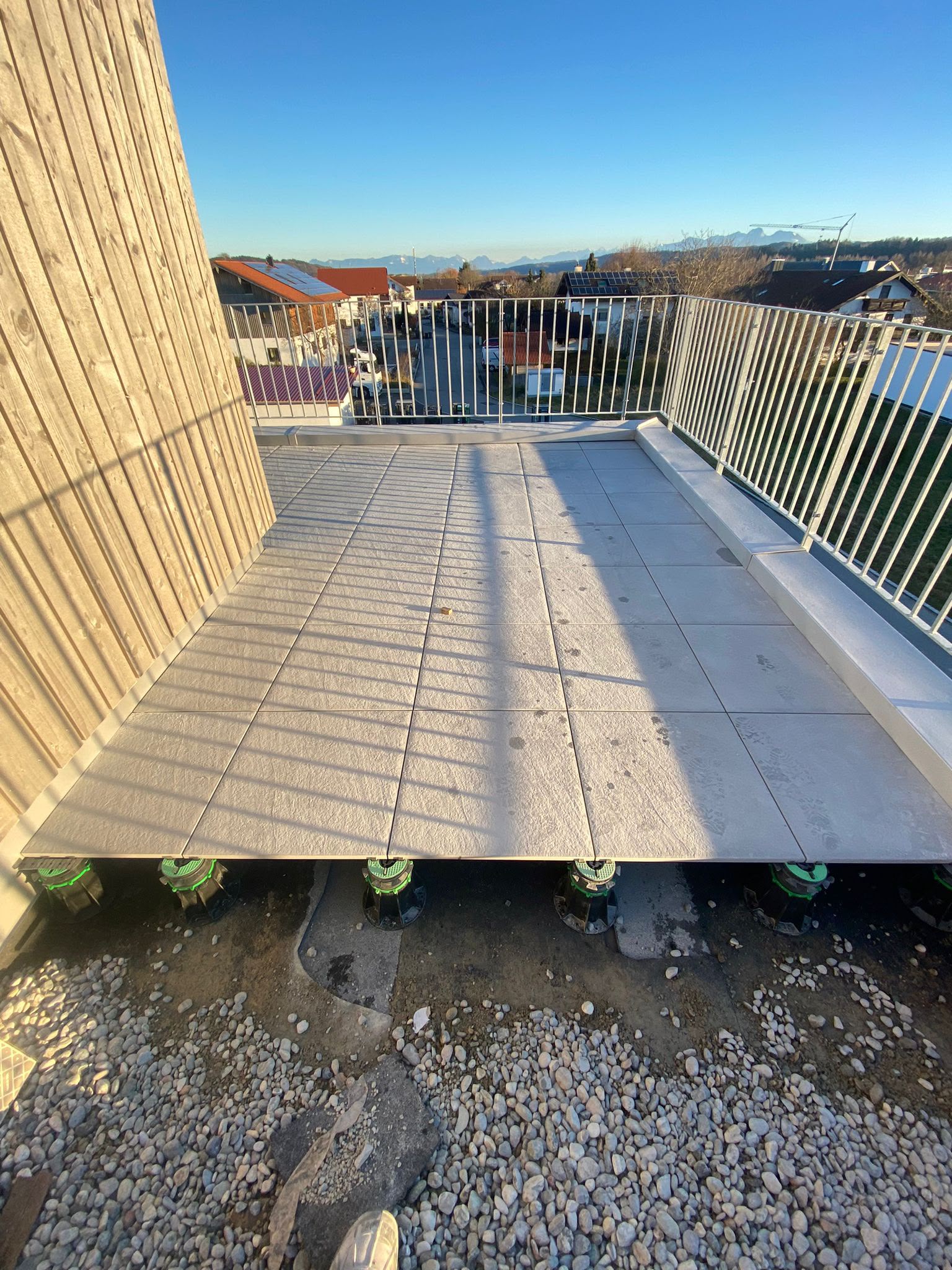 Balkon mit grauen Bodenplatten und Metallgeländer nach den Bodenarbeiten